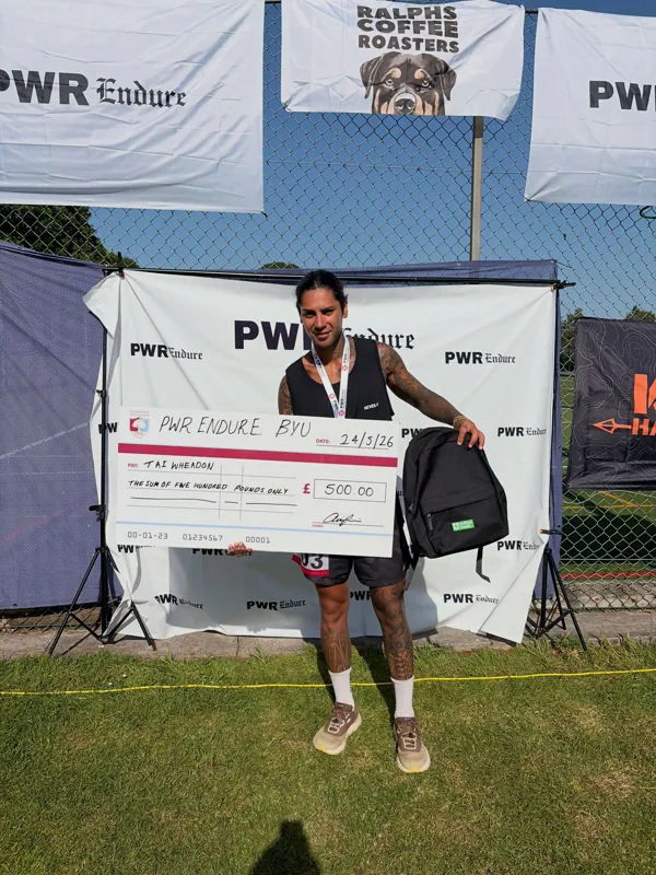 A runner with his medal and presentation cheque at PWR’s 2026 ultra